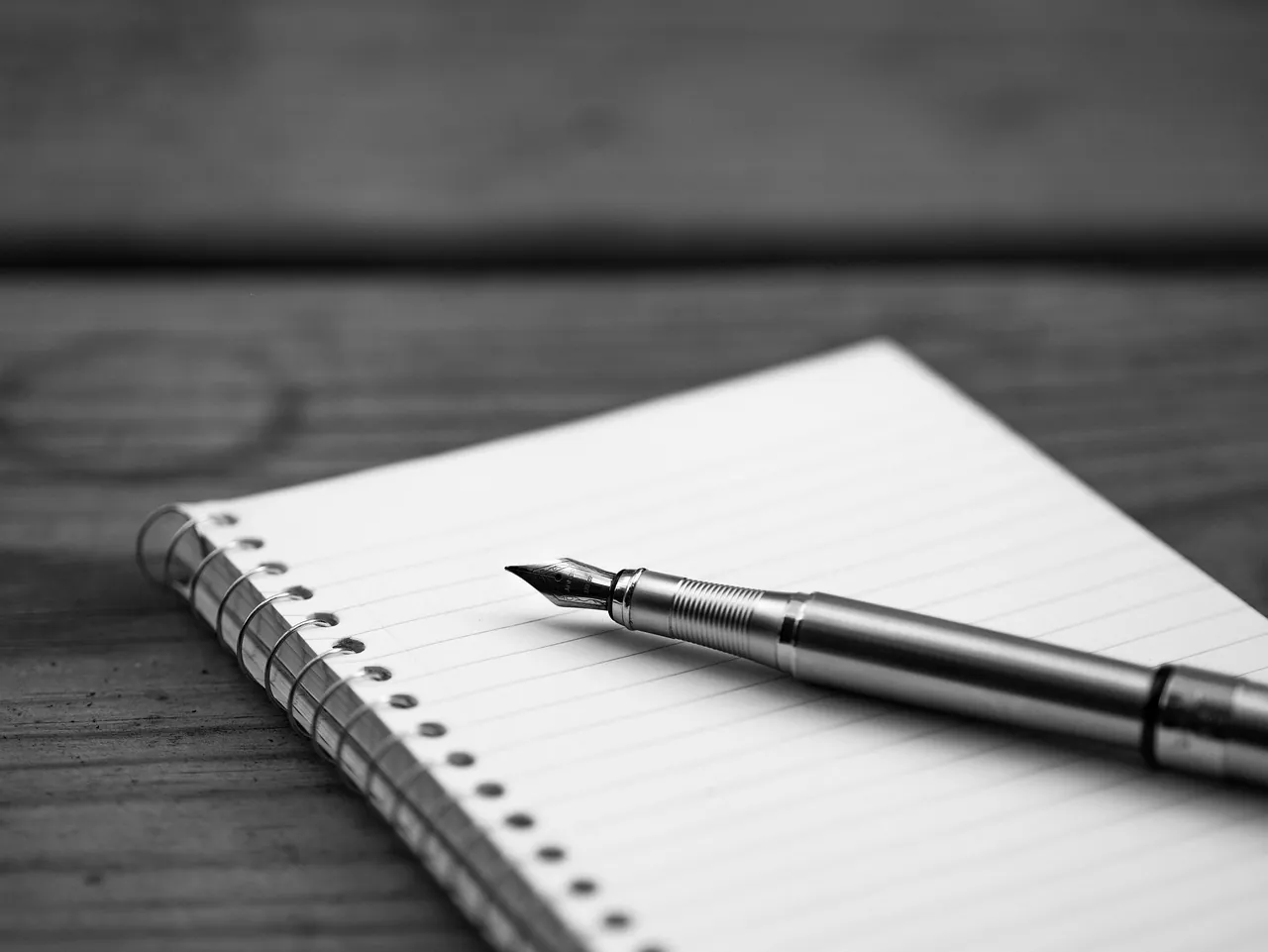 Carnet à spirale ouvert avec un stylo plume posé sur une page vierge